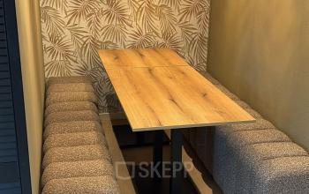 Stijlvolle kantoorruimte huren op Hollandse Kade 38 in Abcoude met comfortabele zitbanken en houten tafel onder stijlvolle hanglampen.