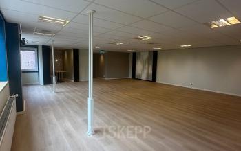 Ruime kantoorruimte te huur op Hollandse Kade 38, Abcoude. Het interieur is ongemeubileerd met een houten vloer en helder verlichte plafonds, ideaal voor kantoorpand aanpassingen en personalisatie.
