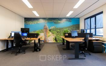 Kantoorruimte huren bij Bedrijvenpark Twente 305 in Almelo, met werkplekken, bureaus en muurdecoratie van een natuurfoto.