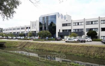 Bedrijvenpark Twente 305 in Almelo, kantoorpand met moderne uitstraling, grote parkeerplaats en aangrenzend groen.