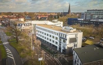 Buitenaanzicht van een modern kantoorpand aan de Brugstraat 9-13 in Almelo met uitzicht op de omgeving. Ideaal voor bedrijven die kantoorruimte willen huren in een goed bereikbare locatie.