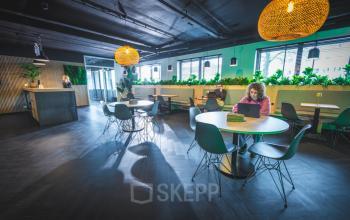 Gezellige kantoorruimte op Brugstraat 9-13 in Almelo met moderne inrichting. Personen werken in een lichte open ruimte met tafelopstelling, ideaal voor kantoorruimte huren.