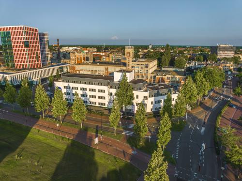 Luchtfoto van het kantoorpand aan de Egbert Gorterstraat 2-14 in Almelo, omringd door bomen en straten. Ideale locatie voor kantoorruimte huren in een stedelijke omgeving met goede toegankelijkheid.