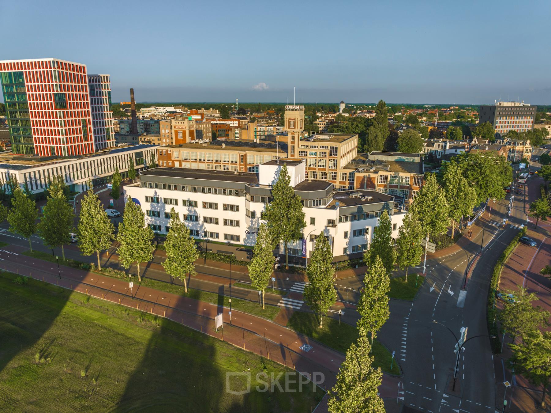 Luchtfoto van het kantoorpand aan de Egbert Gorterstraat 2-14 in Almelo, omringd door bomen en straten. Ideale locatie voor kantoorruimte huren in een stedelijke omgeving met goede toegankelijkheid.