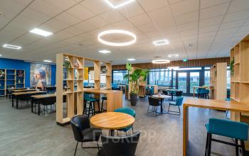 Modern ingericht kantoor met houten accenten en comfortabel meubilair op Plesmanweg 9, ideaal voor ondernemers die een kantoorpand willen huren in Almelo.