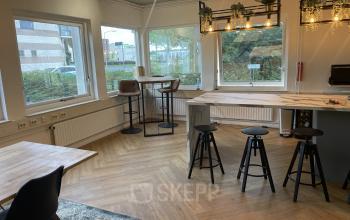 Moderne en goed verlichte kantoorruimte in kantoorpand aan de Kabelstraat 5 in Almere, met houten meubilair en plantendecoratie.