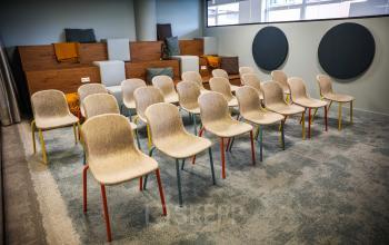 Binnenkant van kantoorpand P.J. Oudweg 41, Almere Stad met opstelling van stoelen en zitplaatsen op een verhoogde tribune.
