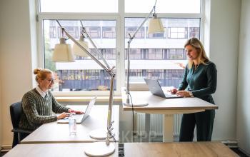 Rustige kantoorruimte huren op P.J. Oudweg 41 in Almere Stad, Almere. Twee vrouwen werken geconcentreerd aan bureaus, goed verlichte omgeving met grote ramen.