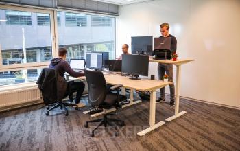 Kantoorruimte te huur op P.J. Oudweg 41 in Almere Stad, met drie personen die aan bureau's werken, voorzien van moderne meubels en grote ramen.