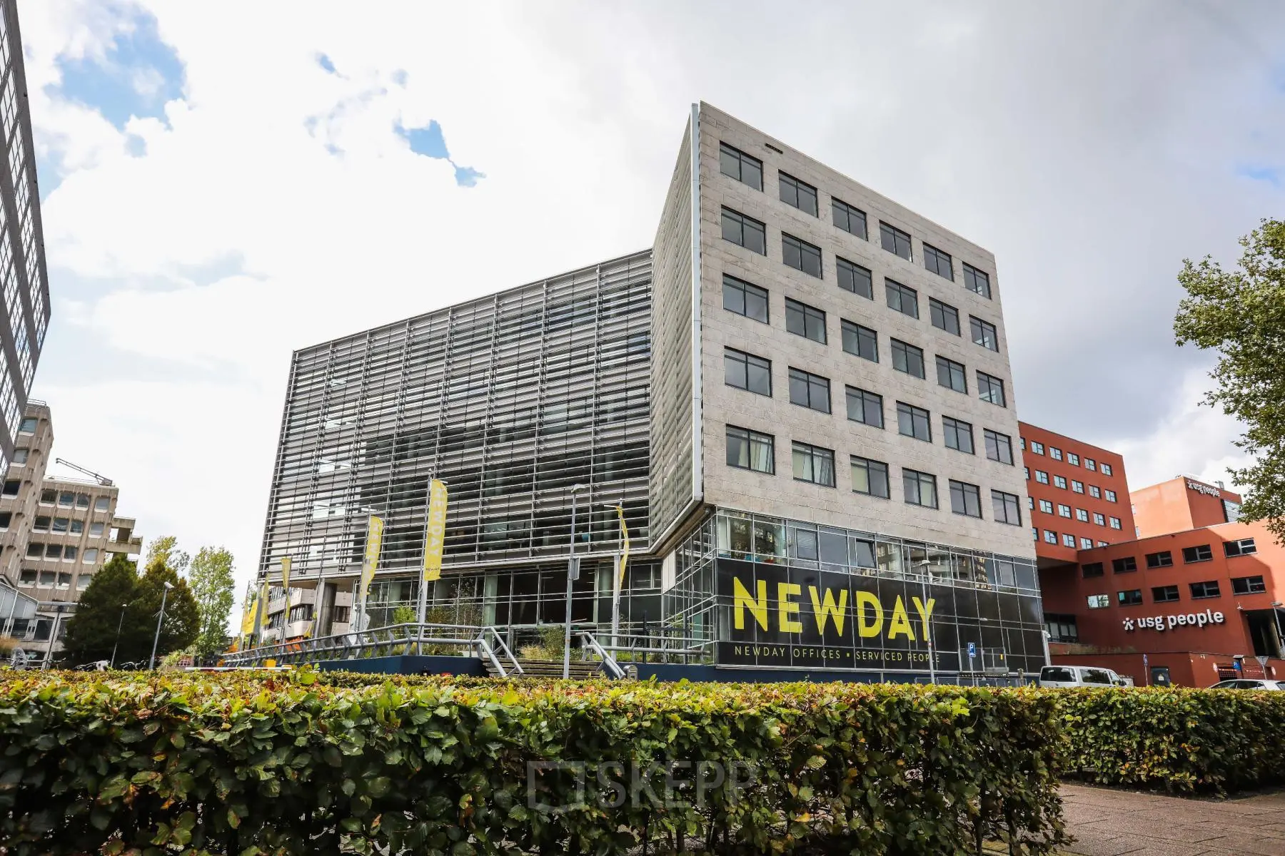 Exterieur van kantoorpand op P.J. Oudweg 41, Almere Stad, met moderne glazen gevel, geel NEWDAY logo en aangrenzende kantoren.