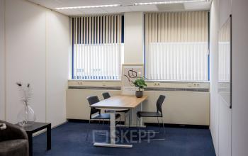Kantoorruimte huren aan Markerkant 1310 in Almere Stad, Almere; kleine vergaderruimte met tafel, stoelen en een raam met jaloezieën.