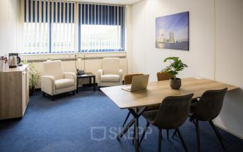 Gemeubileerde kantoorruimte huren op Markerkant 1310, Almere Stad: vier stoelen, tafel, scheidingswand, kast, en raam met jaloezieën.