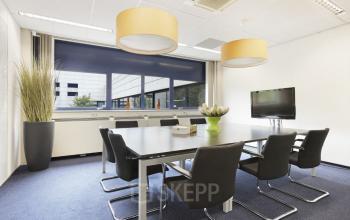 Moderne vergaderruimte in kantoorpand op Markerkant 1310, Almere Stad, met stijlvolle tafel, comfortabele stoelen en grote ramen.