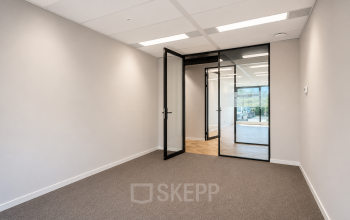 Kantoorruimte op Veluwezoom 15 in Almere Stad met strakke muren en glazen deuren. Ideaal voor wie een kantoor wil huren en een startklare werkplek zoekt.