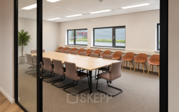 Vergaderruimte in het kantoorpand op Veluwezoom 15, Almere Stad met een lange tafel en comfortabele stoelen een uitnodigende omgeving om kantoorruimte te huren.