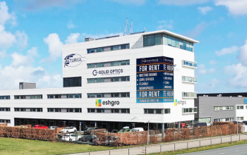 Modern kantoorpand te huur op Veluwezoom 15, Almere Stad, met opvallende gevelreclames voor diverse bedrijven.