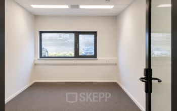 Een kantoorpand aan Veluwezoom 15 in Almere Stad met een lege ruimte die uitnodigt om te huren. Grote ramen zorgen voor natuurlijk licht, ideaal voor het inrichten van kantoren.