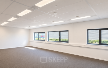 Lichte, open kantoorruimte met grote ramen aan de Veluwezoom 15 in Almere Stad, geschikt voor wie een functionele kantoorruimte wil huren. Neutraal interieur biedt potentieel voor een persoonlijke touch.