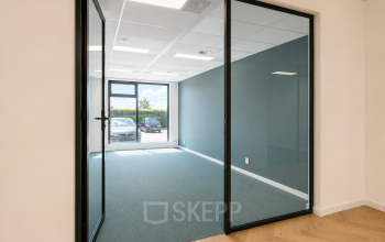 Licht kantoor op Veluwezoom 15 in Almere Stad met glazen deuren en groene vloerbedekking, direct beschikbaar voor huur.