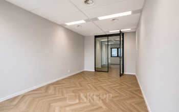 Ongemeubileerde kantoorruimte te huur aan Veluwezoom 15 in Almere Stad met houten vloer en glazen deur, ideaal voor een persoonlijke touch in je nieuwe kantoor.