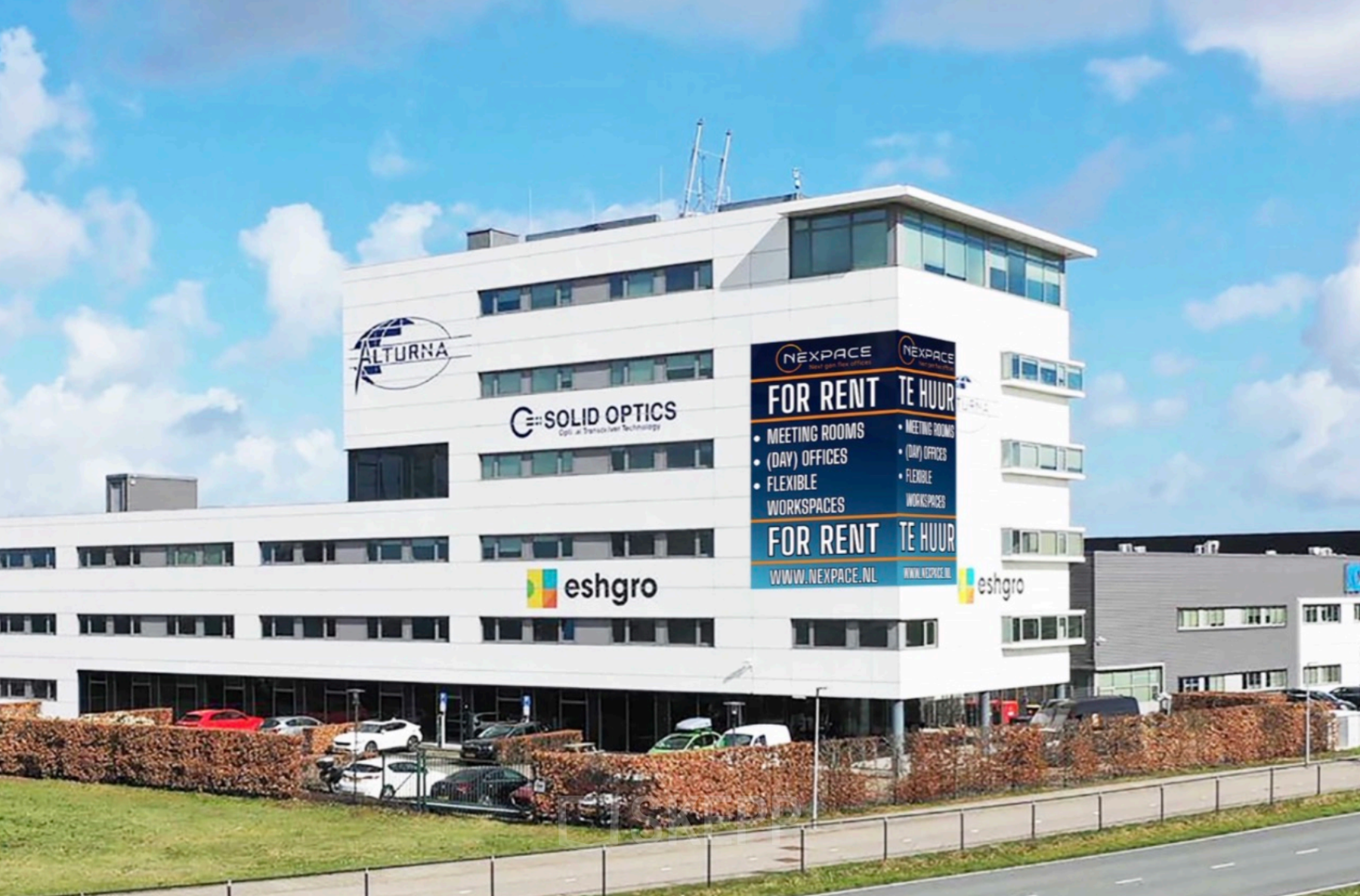 Modern kantoorpand te huur op Veluwezoom 15, Almere Stad, met opvallende gevelreclames voor diverse bedrijven.