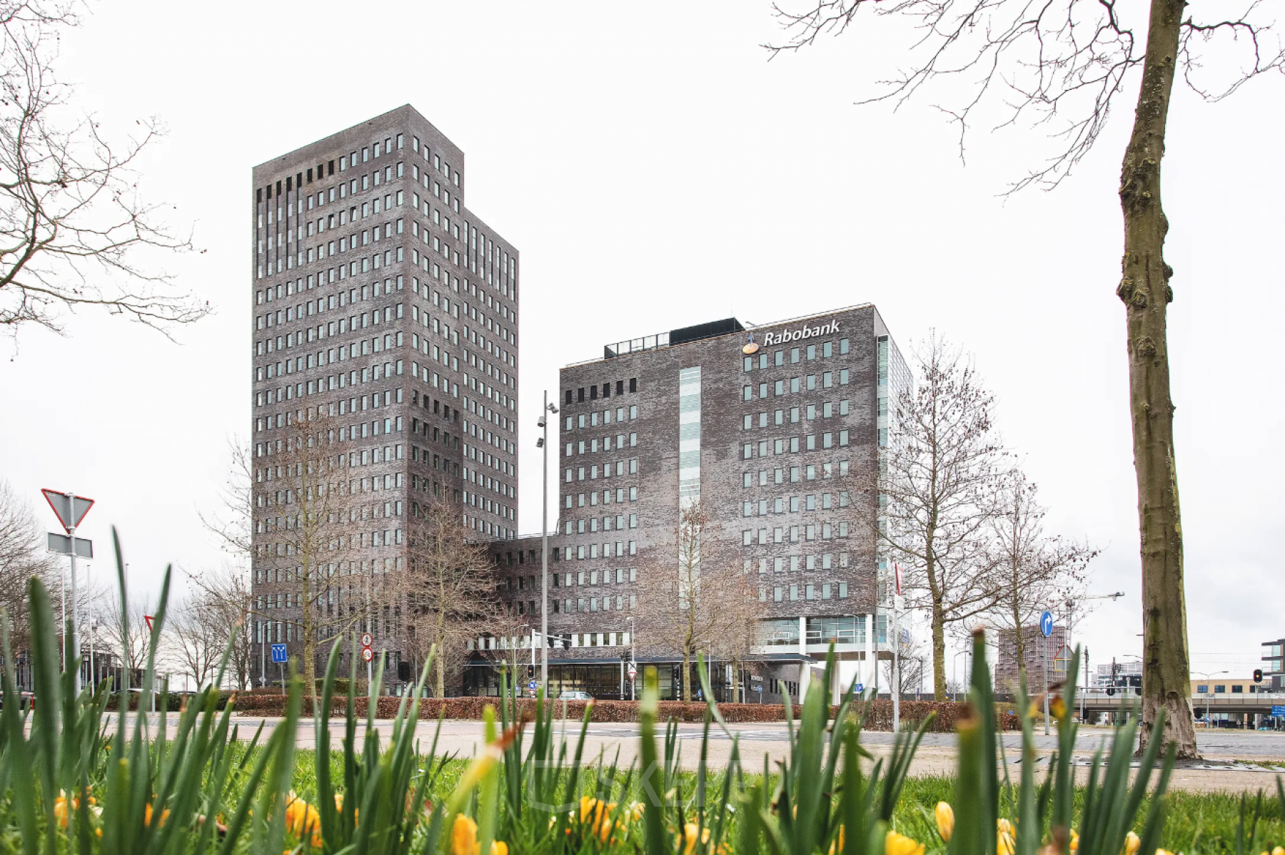 Kantoorpand aan de Landdrostdreef 124 in Almere Stad met moderne architectuur, omringd door groen en een open straat. Ideaal voor bedrijven die kantoorruimte willen huren in een levendige zakelijke omgeving.