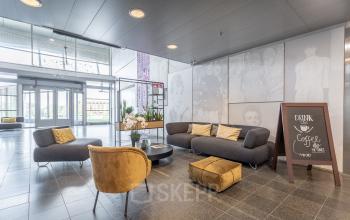 Moderne ontvangsthal met comfortabele zitmeubels en decoratieve elementen in het kantoorpand op Veluwezoom 5, Almere Veluwsekant. Perfect voor bedrijven die kantoorruimte willen huren.