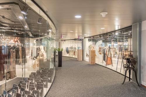 Glazen wand in een kantoorpand aan Veluwezoom 5, Almere Veluwsekant, met een moderne uitstraling. Licht interieur zichtbaar door de etalage met diverse displays in een presentatieomgeving.