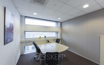 gemeubileerde kantoorkamer bureau kast stoelen vloerbedekking raam muurschildering uitzicht kantoorgebouw almere vlakbij centraal station busplein huur SKEPP