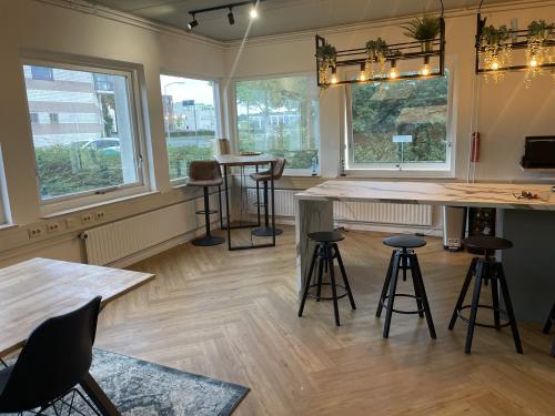 Moderne en goed verlichte kantoorruimte in kantoorpand aan de Kabelstraat 5 in Almere, met houten meubilair en plantendecoratie.