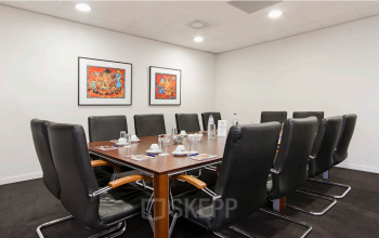 Vergaderruimte in kantoorpand gelegen op Leidse Schouw 2, Alphen aan den Rijn, met een lange tafel en comfortabele stoelen, geschikt voor kantoorruimte huren.