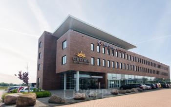 Buitenaanzicht van het kantoorpand op Leidse Schouw 2, Alphen aan den Rijn, met het logo van Crown Business Center op de gevel. Parkeerplaatsen zijn voor het gebouw zichtbaar.