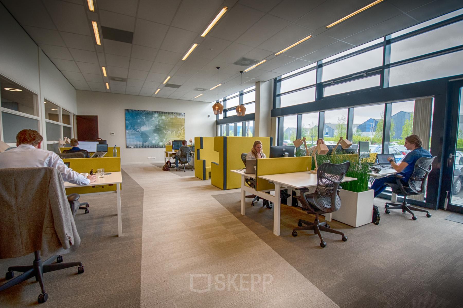 Zakelijke kantoorruimte op Leidse Schouw 2 in Alphen aan den Rijn met werkplekken, moderne meubels en grote ramen voor veel daglicht. Mensen zijn aan het werk, ontworpen voor professionele huur.