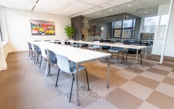 Vergaderruimte in Alphen aan den Rijn met lange tafels en stoelen bij kantoorpand op Europalaan 16, ideaal voor kantoorruimte huren.