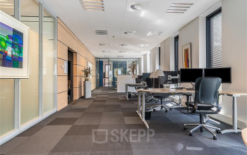 Modern ingericht kantoorpand op Flemingweg 8 in Alphen aan den Rijn met werkplekken en bureaus met computers. Voldoende daglicht door grote ramen.