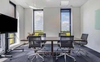 Zakelijke kantoorruimte huren in kantoorpand op Flemingweg 8, Alphen aan den Rijn. Moderne vergaderruimte met grote ramen, vergadertafel en stoelen.