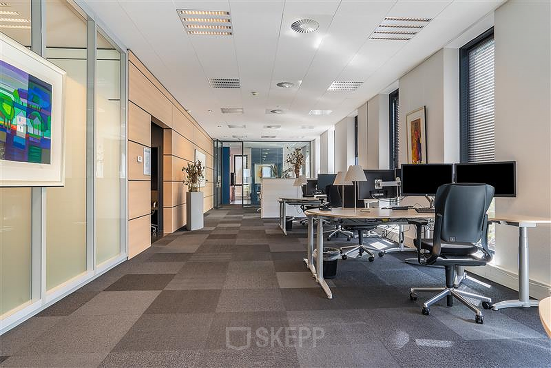 Modern ingericht kantoorpand op Flemingweg 8 in Alphen aan den Rijn met werkplekken en bureaus met computers. Voldoende daglicht door grote ramen.