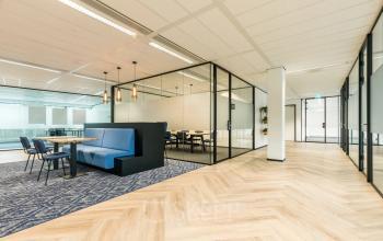 Moderne kantoorruimte in Amersfoort Calveen met glazen wanden en houten vloer, ideaal voor het huren van een flexibele werkplek in kantoorpand Spoetnik 10-64.