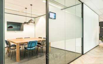 Vergaderruimte in kantoorpand Spoetnik 10-64 in Amersfoort Calveen met glazen wanden, grote houten tafel en stoelen, ideaal voor kantoorruimte huren.