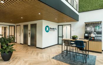 Moderne kantoorruimte in Amersfoort Calveen bij Spoetnik 10-64 met een open en lichte lobby, voorzien van liften, zitgedeelte en groene accenten. Ideaal voor wie kantoorruimte wil huren in Amersfoort.