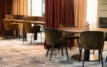 Gezellige kantoorruimte huren in het pand op Ruimtevaart 24, Amersfoort Calveen. Stijlvolle inrichting met comfortabele stoelen en lange tafels, ideaal voor informeel overleg of individueel werk.