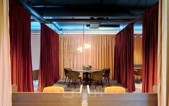 Stijlvolle werkruimte in kantoorpand op Ruimtevaart 24, Amersfoort Calveen, met kleurrijke gordijnen en moderne verlichting. Ideale kantoorruimte huren om samen te werken en te vergaderen.