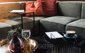 Stijlvol ingerichte loungehoek in kantoorpand aan Ruimtevaart 24, Amersfoort Calveen, met comfortabele banken en een koffietafel.