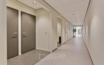 Licht en ruim kantoorpand op Astronaut 28 in Amersfoort Calveen, met moderne afwerking en lange gang zonder mensen. Perfect om kantoorruimte te huren.
