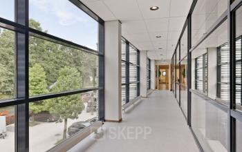 Lichte gang met grote ramen in kantoorpand aan de Astronaut 28 in Amersfoort Calveen, ideaal voor kantoorruimte huren.