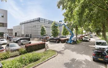 Exterieur van kantoorpand op Astronaut 28, Amersfoort Calveen met parkeerplaatsen en omliggende groene bomen, geschikt voor kantoorruimte huren.