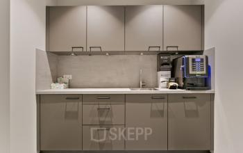 Moderne pantry in kantoorpand Astronaut 28, Amersfoort Calveen, uitgerust met stijlvolle kasten en een koffiezetapparaat. Ideale ruimte voor medewerkers om een pauze te nemen tijdens het werken.