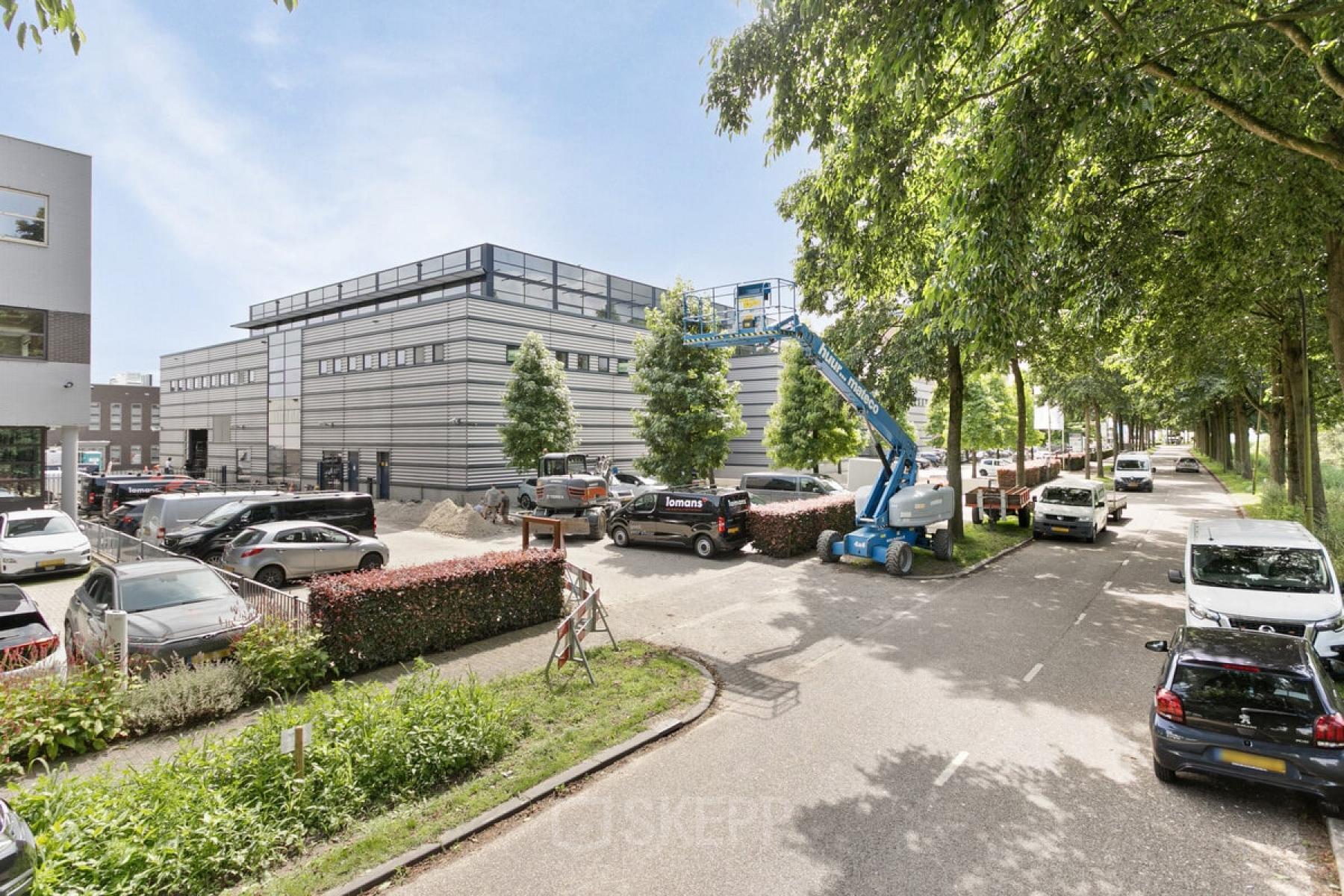 Exterieur van kantoorpand op Astronaut 28, Amersfoort Calveen met parkeerplaatsen en omliggende groene bomen, geschikt voor kantoorruimte huren.
