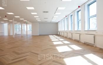 Lichte, open kantoorruimte op Maanlander 43, Amersfoort Calveen, perfect voor het huren van een modern kantoor. Veel ramen zorgen voor natuurlijk licht en de houten vloer geeft een warme uitstraling.