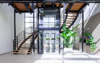 Ruime en lichte entree met moderne trap en glazen lift in een kantoorpand, ideaal voor kantoorruimte huren aan de Maanlander 43 in Amersfoort Calveen.